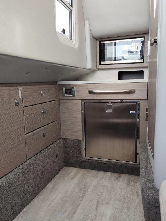 Slide: The Image of 2018 Formula 350 Crossover Bowrider cabin interior with modern cabinetry and stainless steel fridge. - 38
