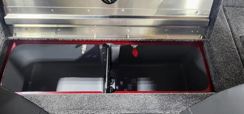 Slide: The Image of 2025 Tracker Pro Team 190 boat storage compartment with carpeted interior and metal trim. - 15