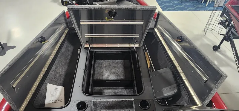 Slide: The Image of 2025 Tracker Pro Team 190 boat interior with open storage compartments and carpeted flooring. - 7