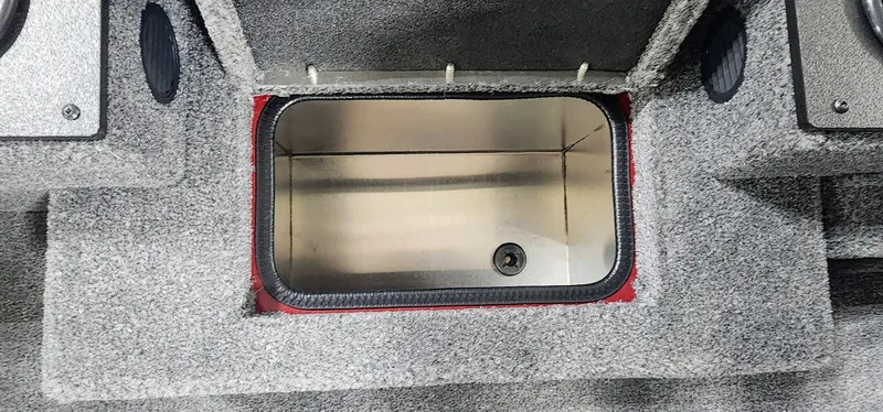 Slide: The Image of 2025 Tracker Pro Team 190 boat storage compartment with gray carpeted interior. - 9