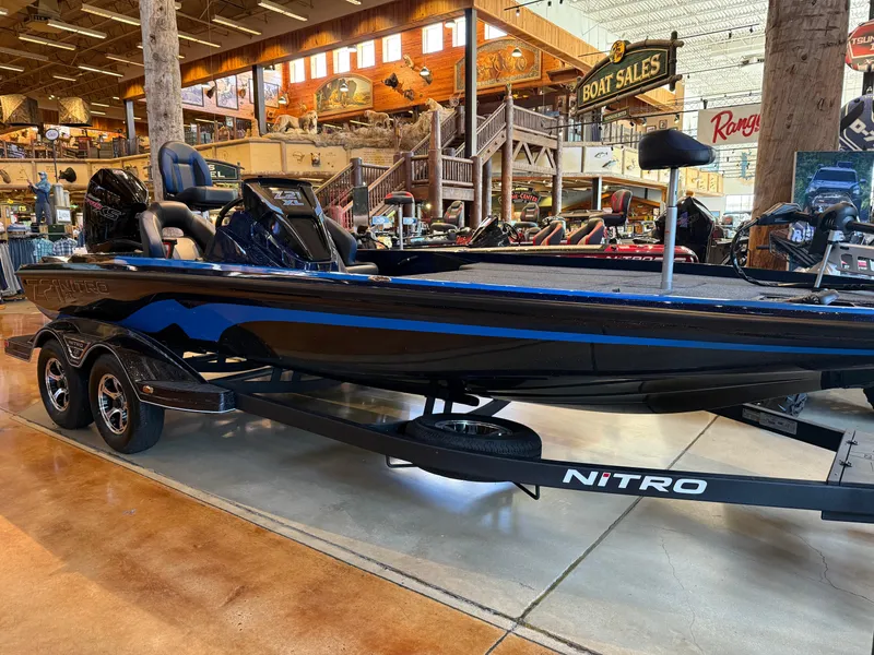 Slide: The Image of 2025 Nitro Z21 XL boat displayed in a showroom with wooden interior decor. - 0