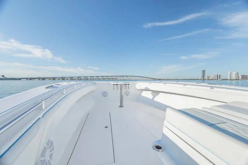 Slide: The Image of 2022 SeaHunter 46 CTS boat on calm water with city skyline in background. - 13