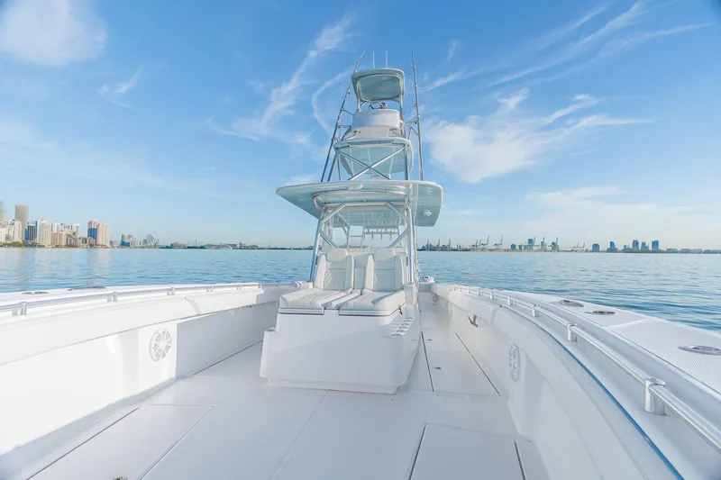 Slide: The Image of 2022 SeaHunter 46 CTS boat on calm water with city skyline. - 15