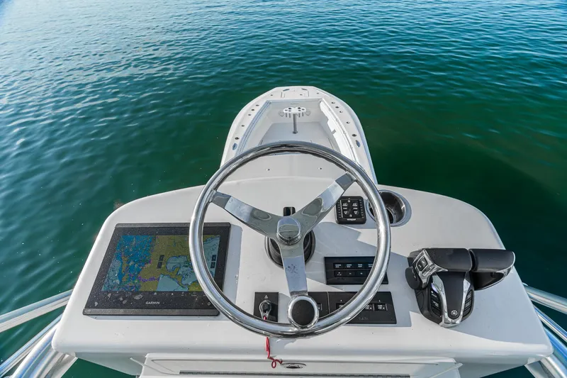 Slide: The Image of SeaHunter 46 CTS 2022 helm with steering wheel and navigation system on calm water. - 18