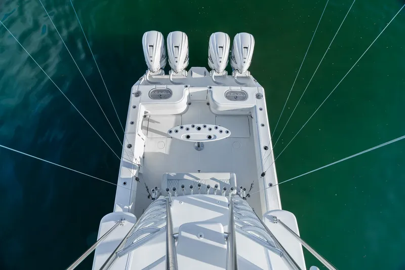 Slide: The Image of Aerial view of 2022 SeaHunter 46 CTS boat with four engines on turquoise water. - 19