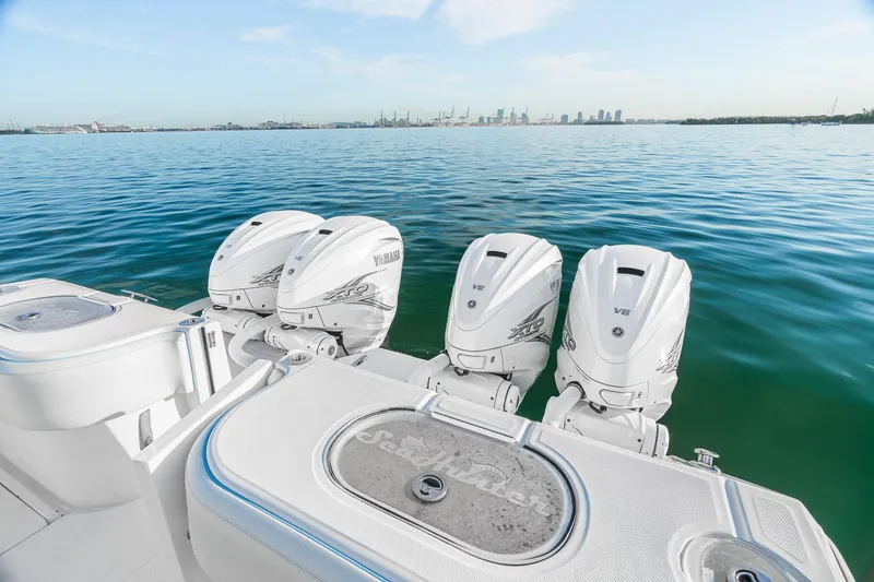 Slide: The Image of 2022 SeaHunter 46 CTS boat with four powerful outboard engines on calm water. - 22