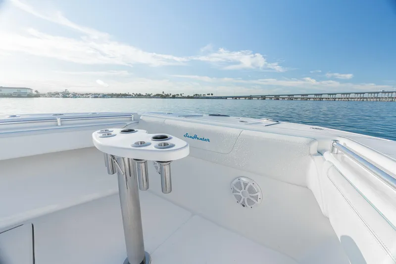 Slide: The Image of 2022 SeaHunter 46 CTS boat interior with rod holders, overlooking calm waters. - 23