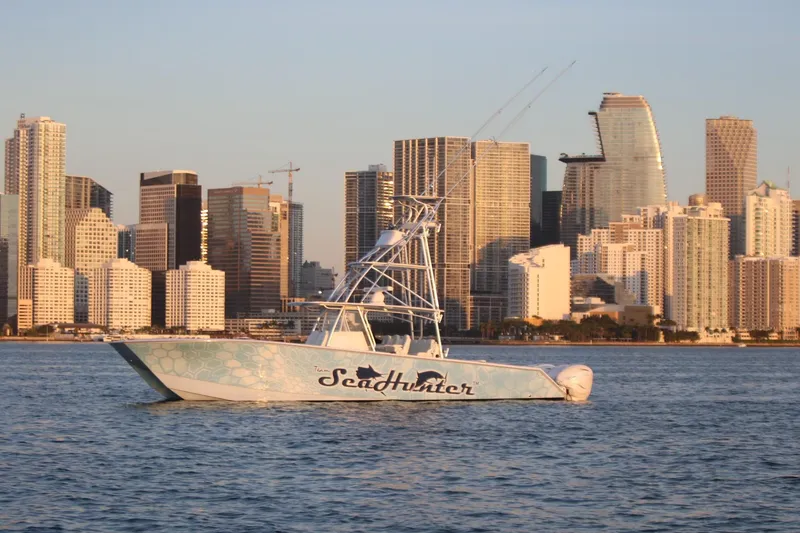 Slide: The Image of SeaHunter 46 CTS boat on water with city skyline in the background, 2022 model. - 25
