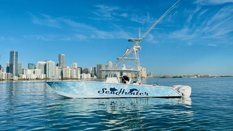 Slide: The Image of 2022 SeaHunter 46 CTS boat on calm water with city skyline background. - 26