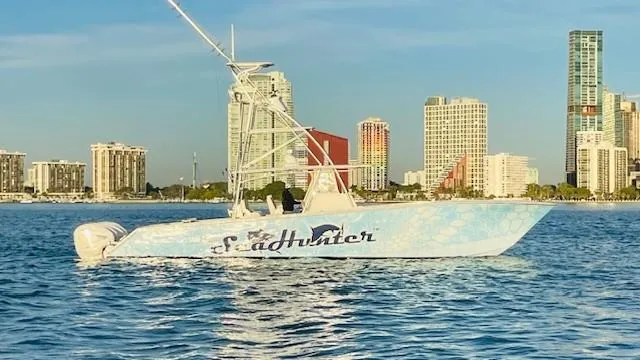 Slide: The Image of SeaHunter 46 CTS 2022 boat on water with city skyline in background. - 29