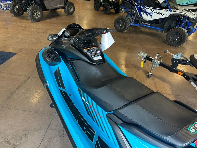 Slide: The Image of 2025 Yamaha WaveRunner FX SVHO in showroom, blue and black design, with off-road vehicles nearby. - 3