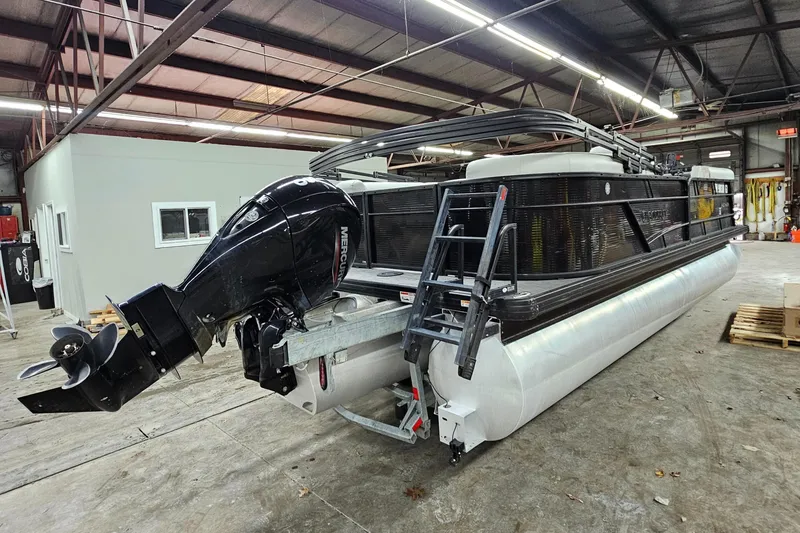 Slide: The Image of 2022 Sweetwater 2286 pontoon boat in a warehouse, featuring a powerful outboard motor. - 6