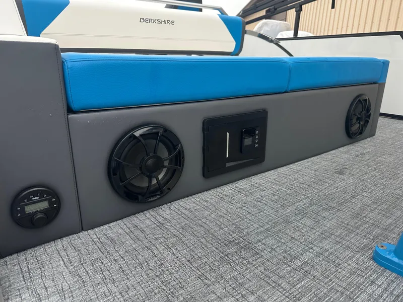 Slide: The Image of 2025 Berkshire 25 ULDCSTS boat interior with blue seating and built-in speakers. - 11