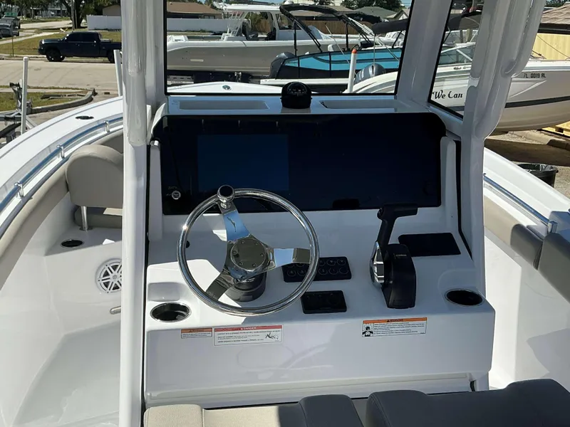 Slide: The Image of 2025 Sportsman 212 Open boat dashboard with steering wheel and controls. - 15
