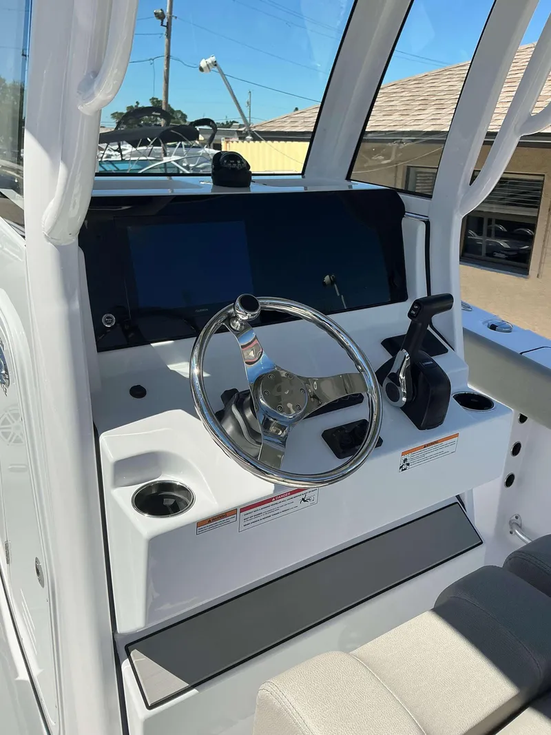 Slide: The Image of 2025 Sportsman 212 Open boat dashboard with steering wheel and controls. - 6