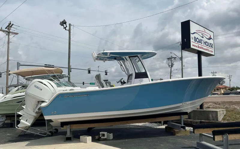 Slide: The Image of 2025 Sportsman 252 Open boat displayed at dealership, featuring Yamaha engine, blue hull. - 1