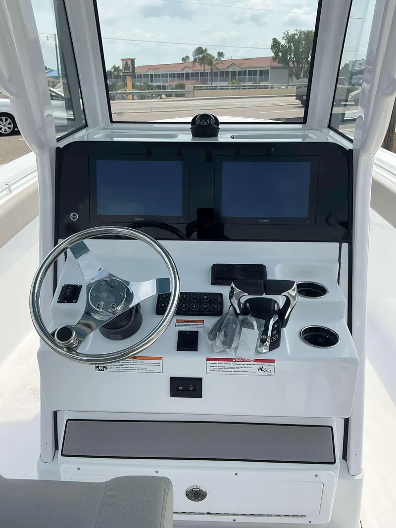 Slide: The Image of 2025 Sportsman 252 Open boat dashboard with dual screens and steering wheel. - 12