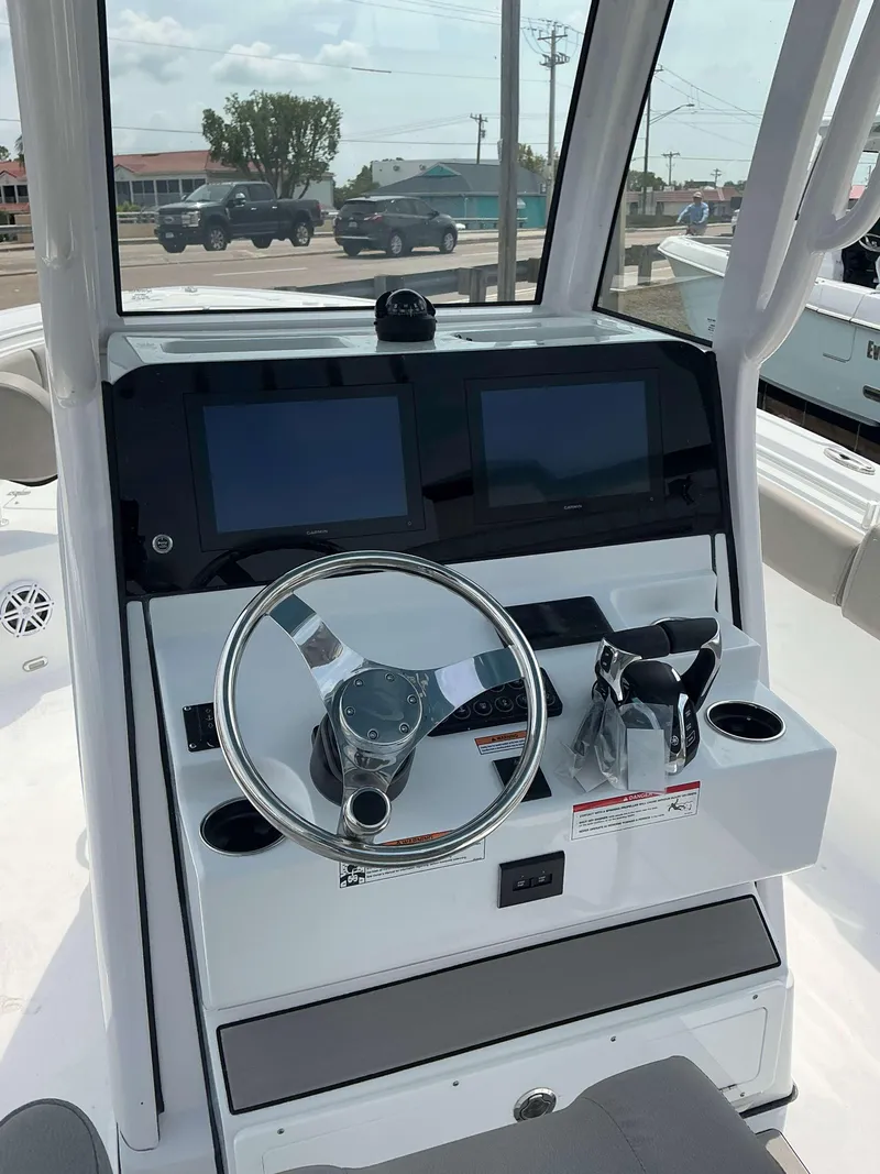 Slide: The Image of 2025 Sportsman 252 Open boat dashboard with dual screens and steering wheel. - 14