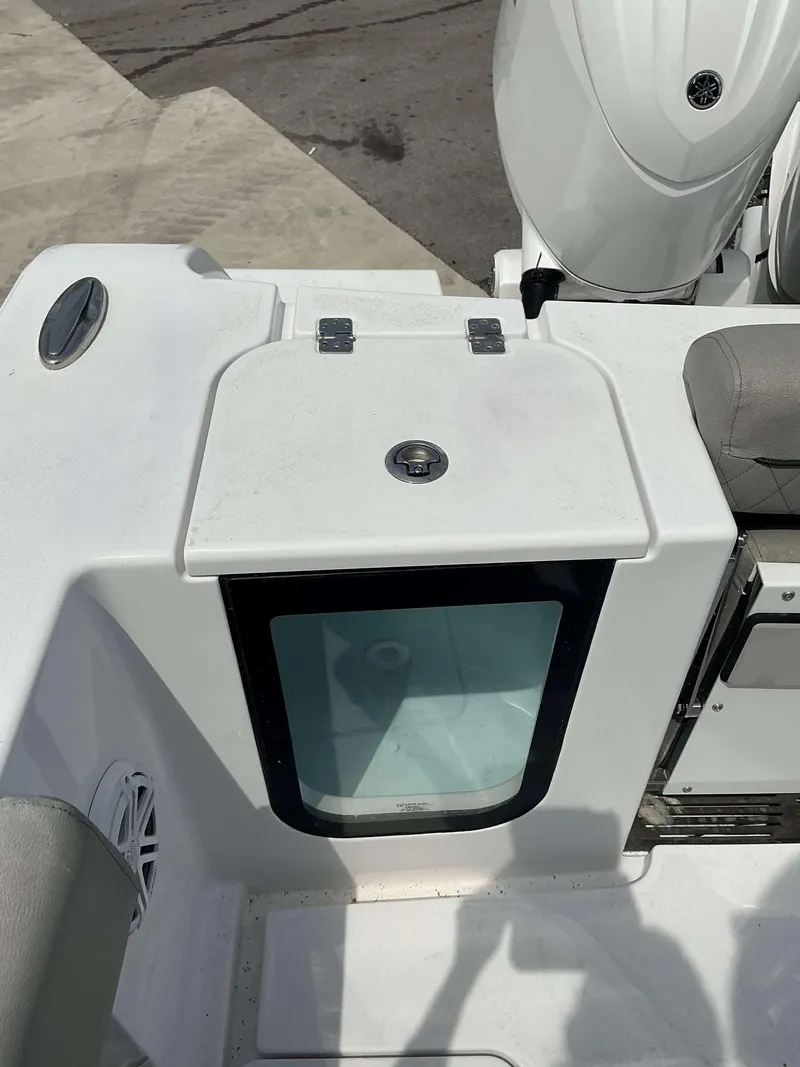 Slide: The Image of 2025 Sportsman 252 Open boat with storage compartment and engine view. - 16