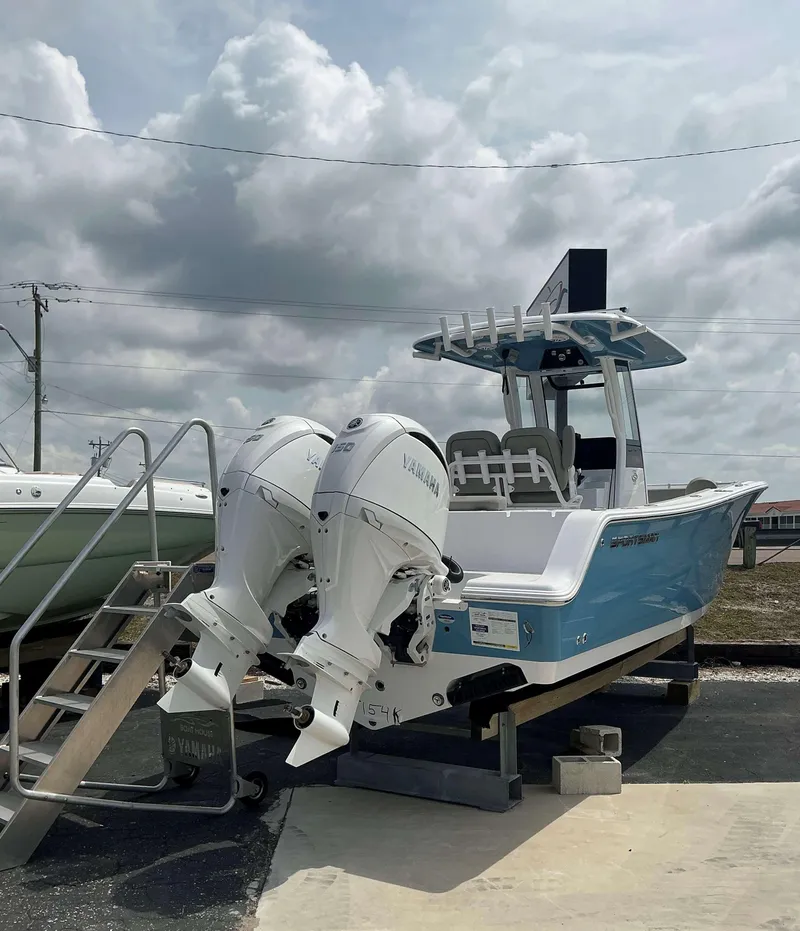 Slide: The Image of 2025 Sportsman 252 Open boat with twin Yamaha engines on display under cloudy sky. - 2