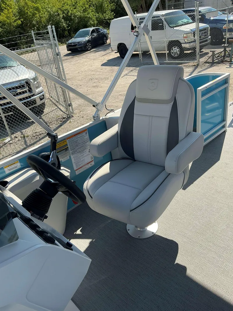 Slide: The Image of 2025 Sweetwater 2286 CSE boat interior with captain's chair and steering wheel. - 10