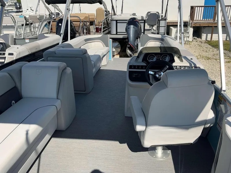 Slide: The Image of 2025 Sweetwater 2286 CSE boat interior with modern seating and steering console. - 13