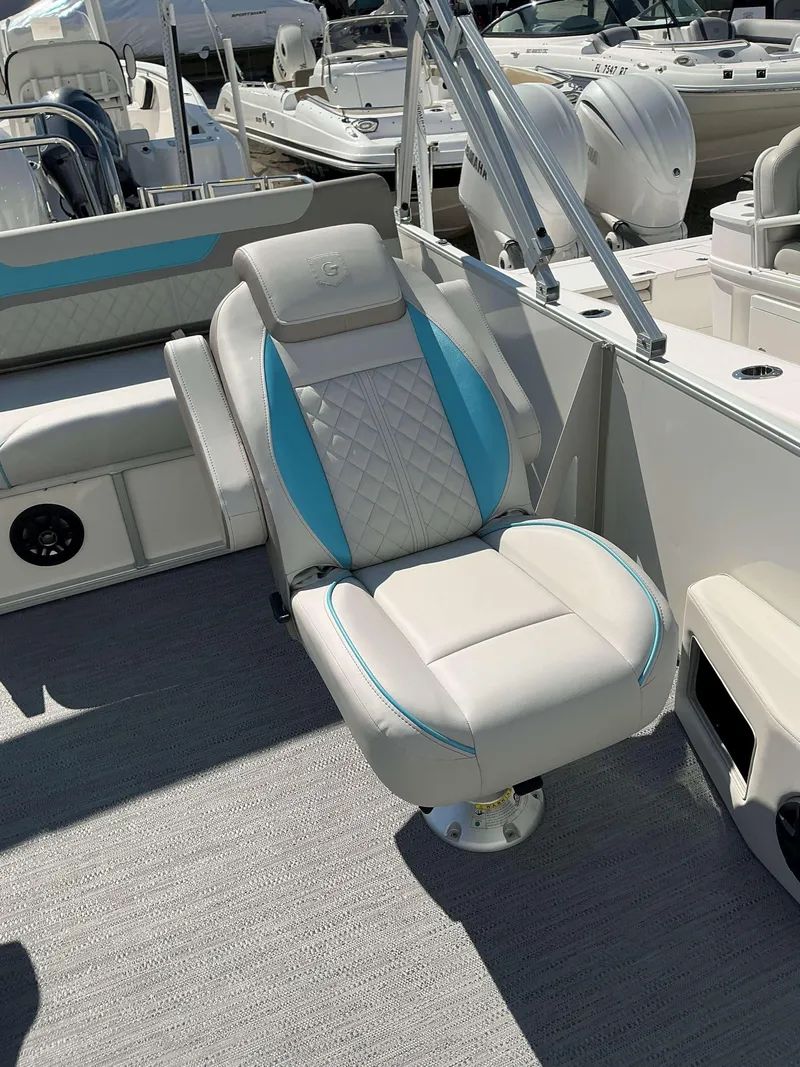 Slide: The Image of 2025 Sweetwater 2486 SFL boat seat with blue accents, docked among other boats. - 10