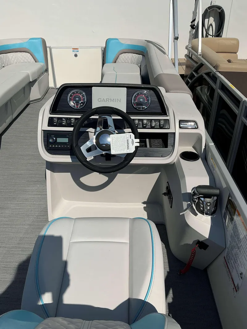 Slide: The Image of 2025 Sweetwater 2486 SFL boat interior with Garmin dashboard and plush seating. - 7