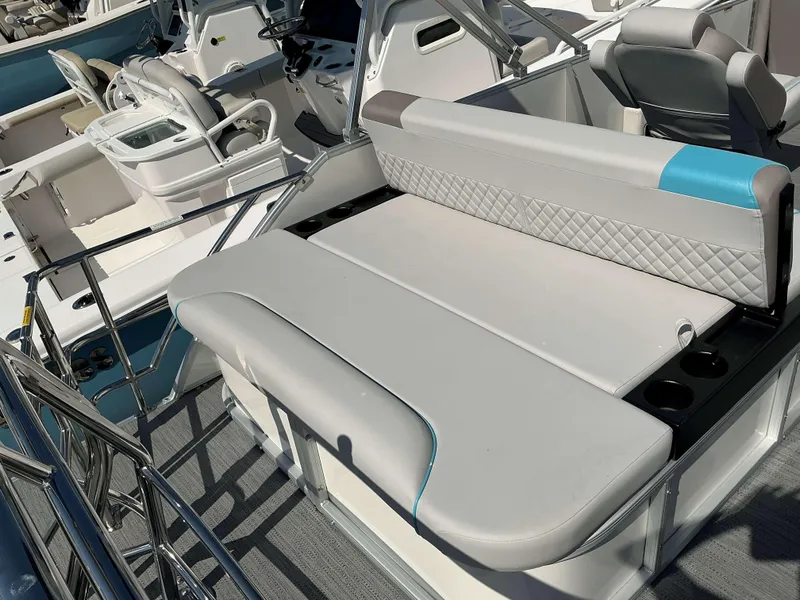 Slide: The Image of 2025 Sweetwater 2486 SFL boat interior with cushioned seating and cup holders. - 9