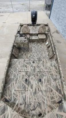 Slide: The Image of 2025 Lowe Roughneck RX1860 SC boat with camouflage design, featuring seating and storage compartments. - 2