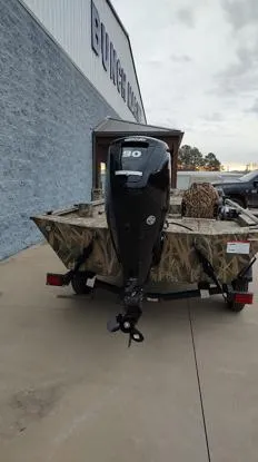 Slide: The Image of 2025 Lowe Roughneck RX1860 SC boat with camo design and powerful outboard motor. - 8