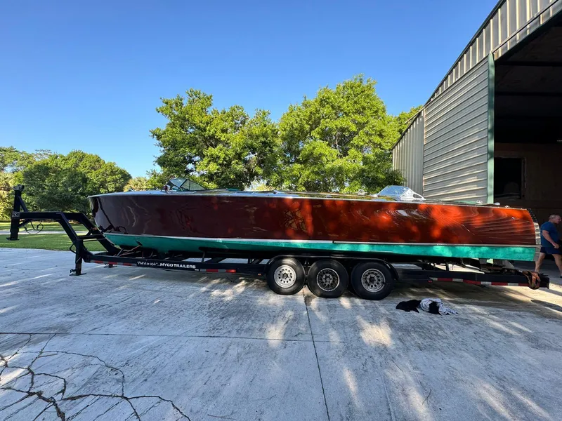 Slide: The Image of Custom 1995 Hugh Saint 34 Grand Prix boat on trailer, parked outside a garage. - 28
