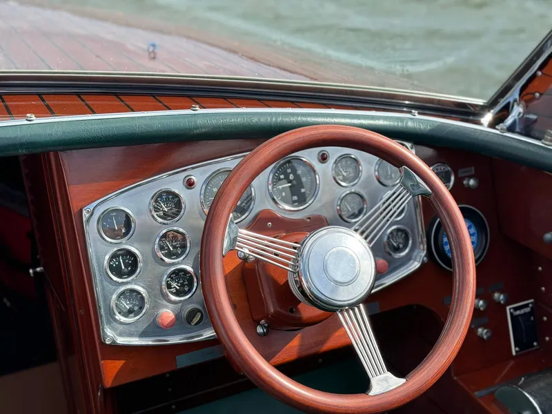 Slide: The Image of Vintage 1995 Hugh Saint 34 Grand Prix boat dashboard with wooden steering wheel and gauges. - 31