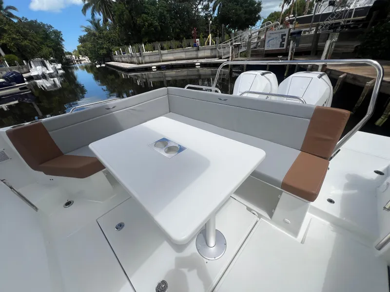 Slide: The Image of 2025 Beneteau Flyer 9 SUNdeck with spacious seating and table, docked by a serene canal. - 15