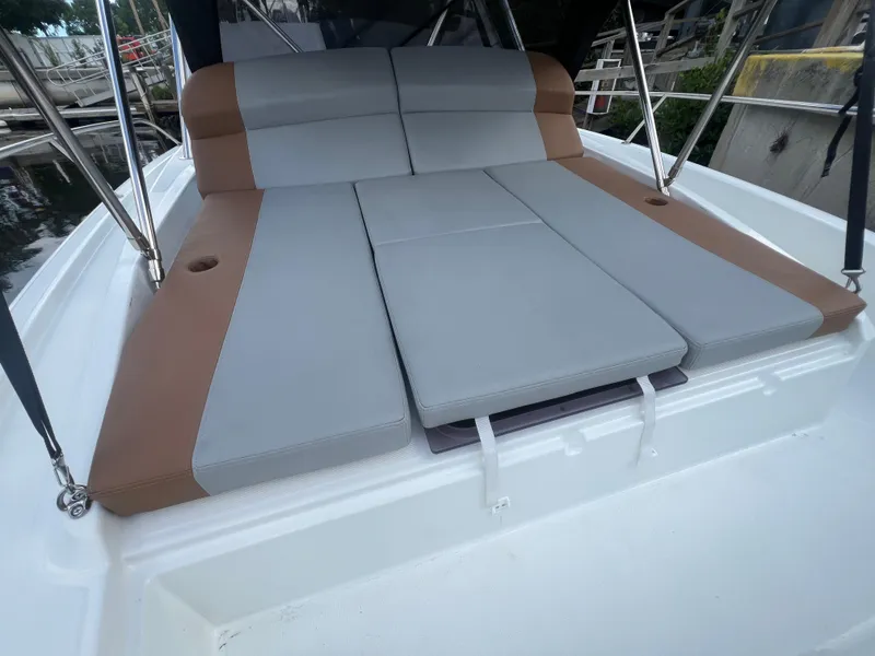 Slide: The Image of 2025 Beneteau Flyer 9 SUNdeck with cushioned sunbathing area, docked at marina. - 5