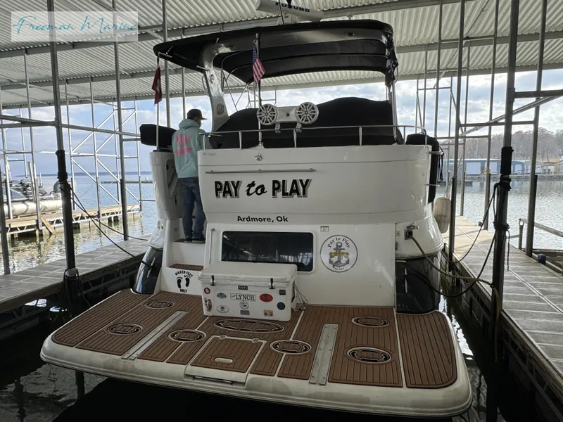 Slide: The Image of 2001 Cruisers Yachts 4450 Express Motoryacht docked, rear view with "Pay to Play" name. - 16