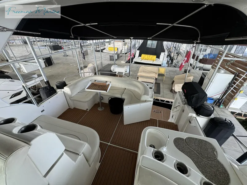 Slide: The Image of 2001 Cruisers Yachts 4450 Express Motoryacht interior with seating and table, docked in marina. - 47