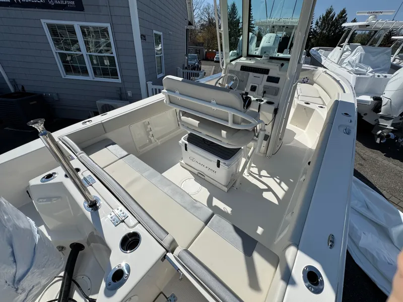 Slide: The Image of 2025 Sailfish 232 CC boat interior with seating and console, docked outdoors. - 18