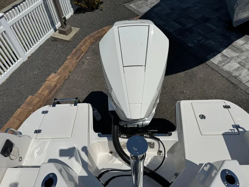 Slide: The Image of 2025 Sailfish 232 CC boat engine and deck, parked on a paved surface. - 20