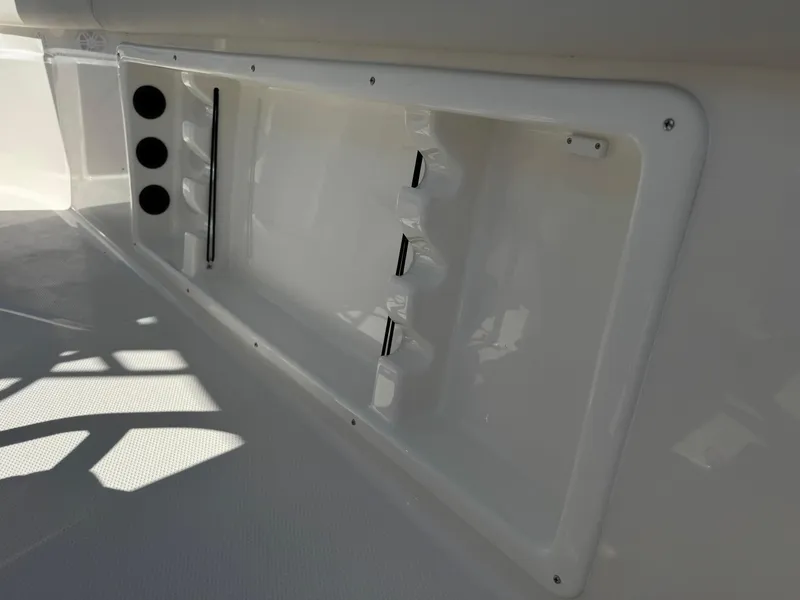 Slide: The Image of 2025 Sailfish 232 CC boat interior storage compartment with rod holders. - 25