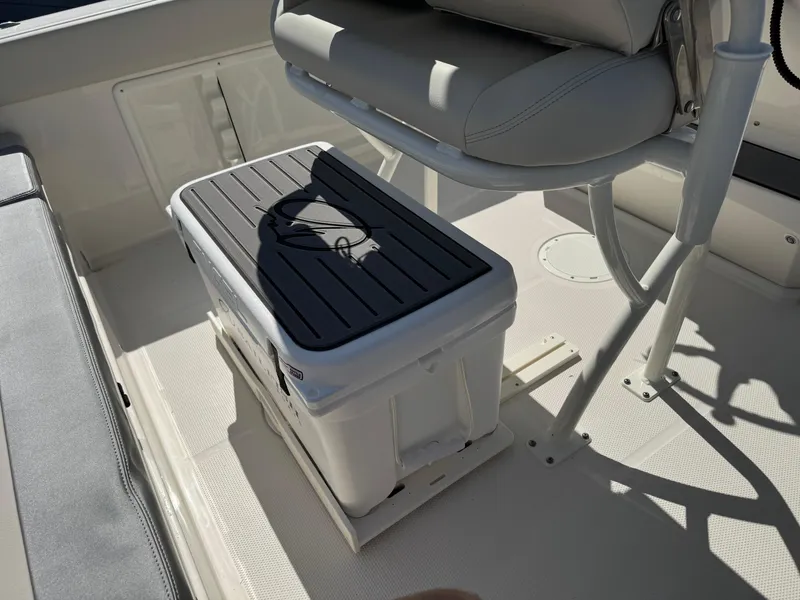 Slide: The Image of 2025 Sailfish 232 CC boat interior with cooler and seating area. - 27