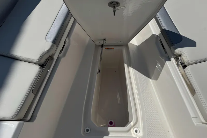 Slide: The Image of 2025 Sailfish 232 CC boat storage compartment with open hatch, showcasing spacious interior. - 9