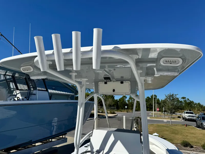 Slide: The Image of 2025 BlackJack 256 Coastal boat with T-top and rod holders under clear blue sky. - 17