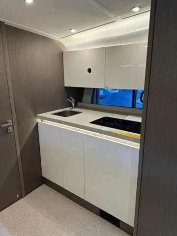 Slide: The Image of 2024 Beneteau Gran Turismo 41 yacht kitchen interior with modern cabinetry and appliances. - 28