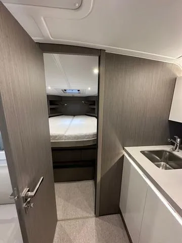 Slide: The Image of 2024 Beneteau Gran Turismo 41 interior with bedroom and kitchenette. - 29