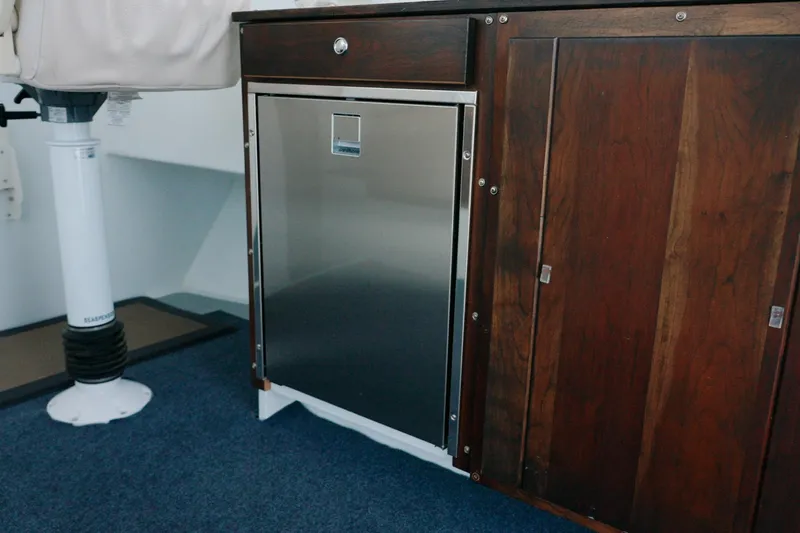 Slide: The Image of Millennium Marine NuWave 37 interior with wooden cabinetry and stainless steel appliance, 2023 model. - 15