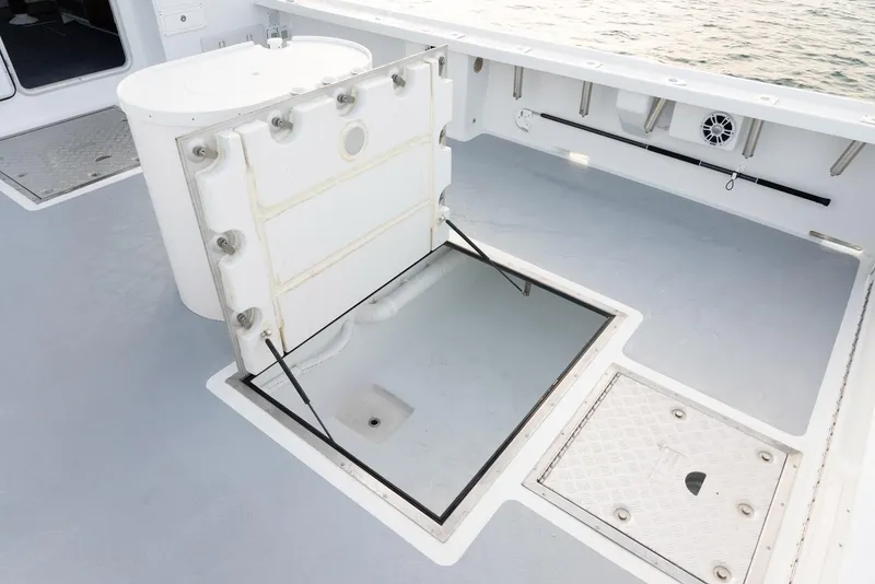 Slide: The Image of Open hatch on 2023 Millennium Marine NuWave 37 boat deck, showcasing storage space. - 29