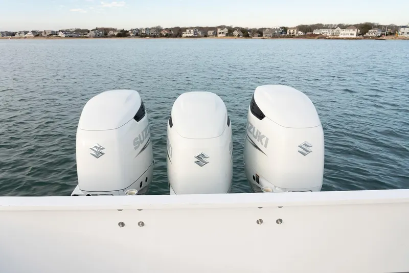 Slide: The Image of 2023 Millennium Marine NuWave 37 with triple Suzuki outboard motors on calm water. - 33