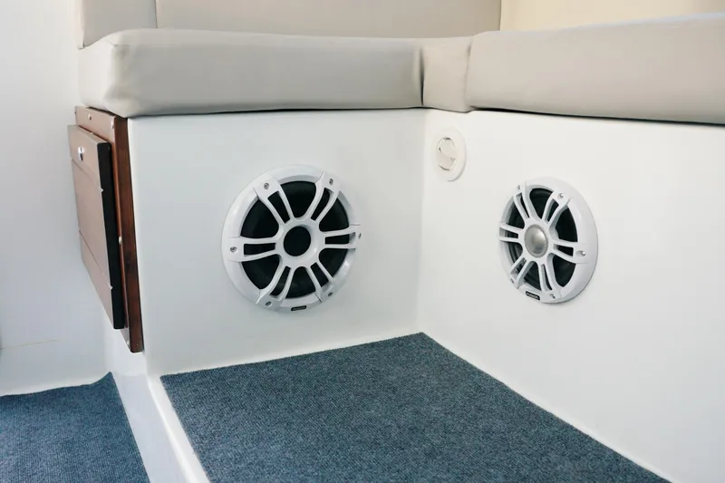 Slide: The Image of 2023 Millennium Marine NuWave 37 interior with built-in speakers and cushioned seating. - 7