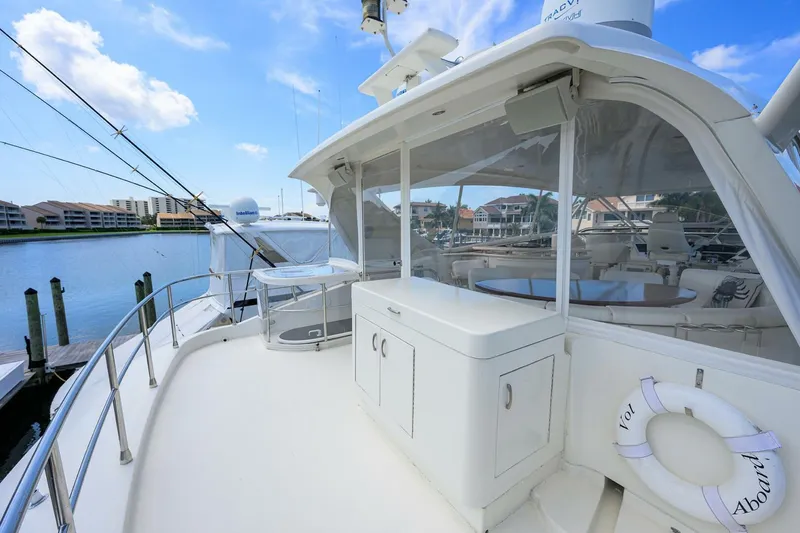 Slide: The Image of 2005 Marquis 65 MY yacht deck with seating and storage, docked by waterfront homes. - 43